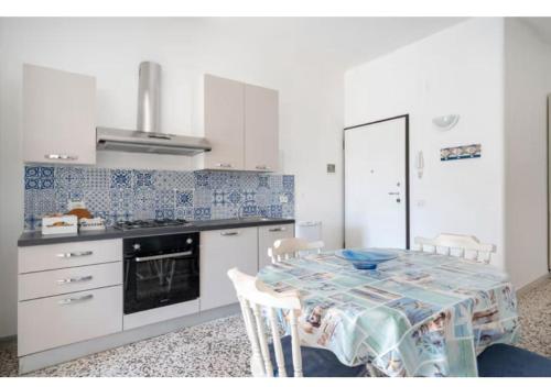 a kitchen with a table and a stove top oven at Residenza Marittima in Torre Canne