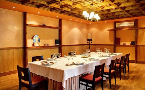 a dining room with a long table and chairs at Oca Palacio De La Llorea Hotel & Spa in Deva