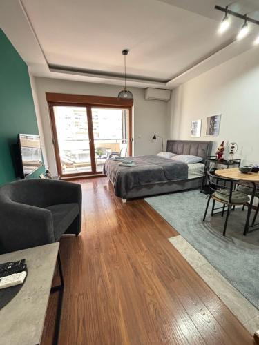 a bedroom with a bed and a couch and a table at Apartman Ana Lux in Podgorica