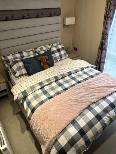 a teddy bear sitting on top of a bed at Tulip 10, Oakdene Forest Park , passes included in Saint Leonards