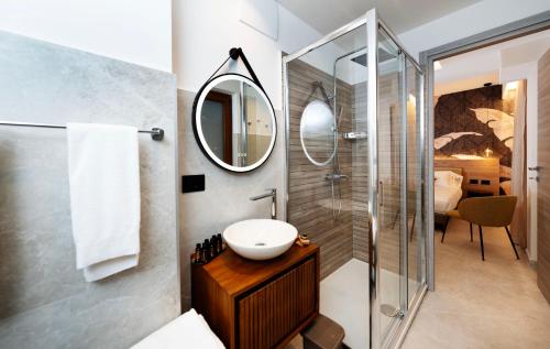 ein Badezimmer mit Dusche, Waschbecken und Spiegel in der Unterkunft Donna Vì Hotel in Geraci Siculo
