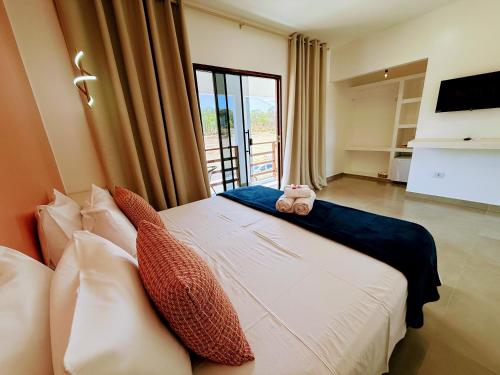 a bedroom with a bed with pillows and a television at Ypê Hospedagem II in Sao Jorge