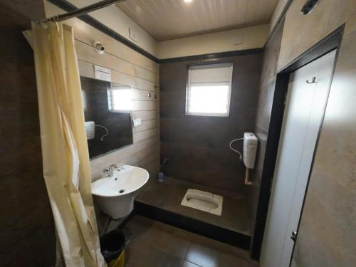 a bathroom with a sink and a toilet at Hotel Grand Inn Jamkhandi in Jamkhandi