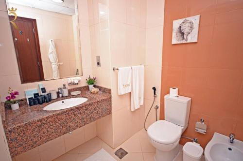 a bathroom with a sink and a toilet and a mirror at Stylish Studio -Bright & Airy Al Reem Retreat in Abu Dhabi