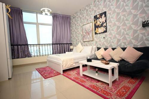 a living room with a couch and a table at Stylish Studio -Bright & Airy Al Reem Retreat in Abu Dhabi