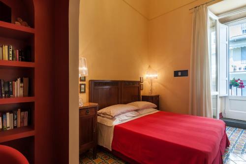 a bedroom with a red bed and a window at Casa Astarita in Sorrento