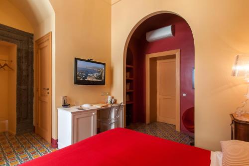 a hotel room with a red bed and a bathroom at Casa Astarita in Sorrento