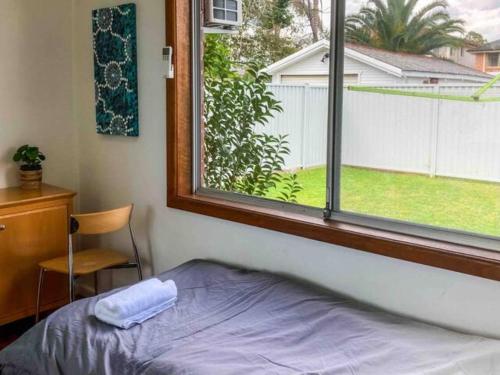 a bedroom with a window and a bed and a desk at Little Red Brick House in Padstow