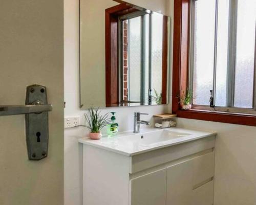 a bathroom with a white sink and a mirror at Little Red Brick House in Padstow