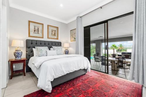 a bedroom with a large bed and a balcony at Fair Glen in Kyalami