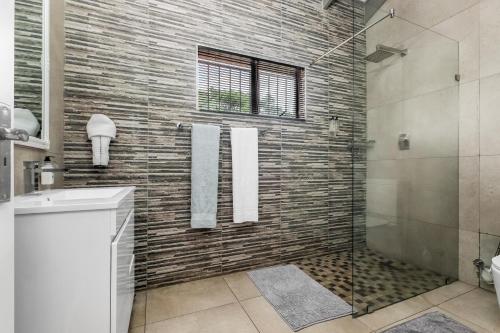 a bathroom with a shower and a glass shower stall at Fair Glen in Kyalami