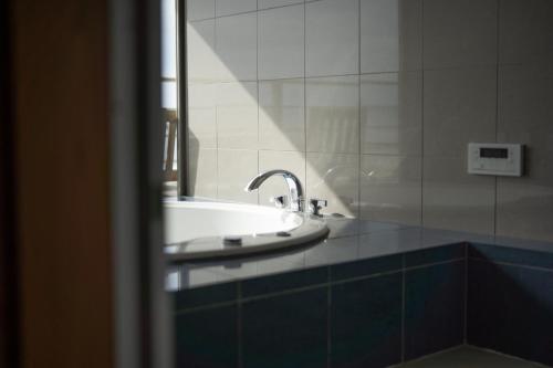 a bathroom with a sink and a mirror at Kaitan稲佐の浜 in Taisha