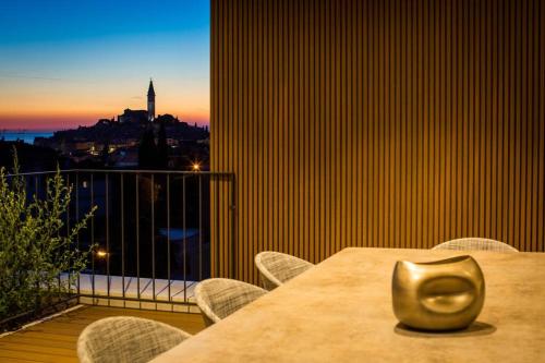 a table with chairs and a view of a city at Z6 Dolcevita Signature - Villa & Private Yacht in the Heart of Rovinj in Rovinj