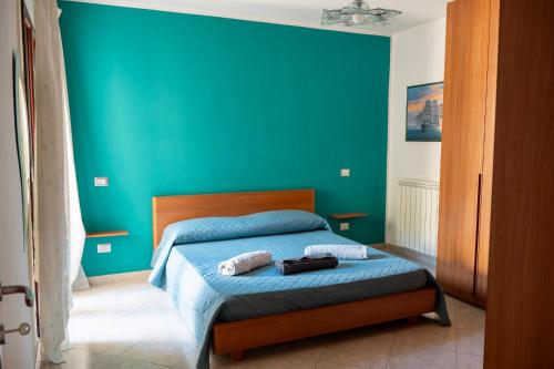 a blue bedroom with a bed with two towels at House Gennauara in Lanusei