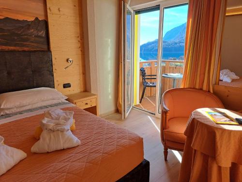 a hotel room with a bed and a balcony at Lake&Nature Hotel Gloria in Molveno