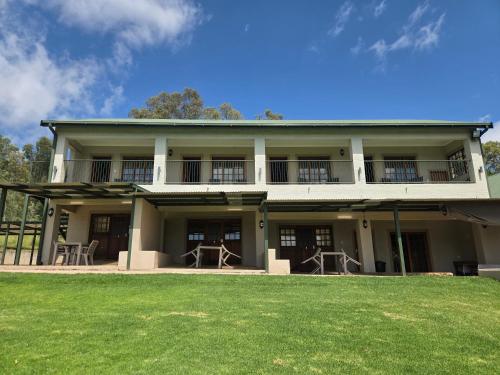 a large house with a lawn in front of it at Merino Guest Farm in Clarens