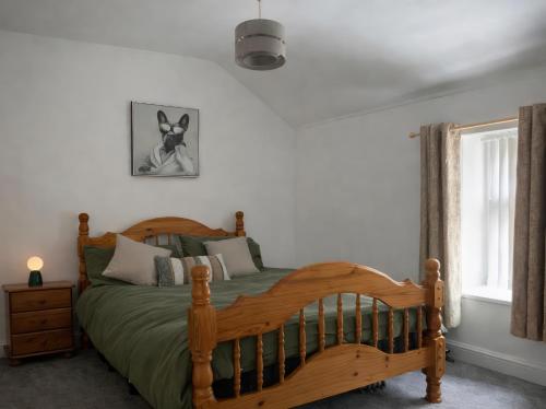 a bedroom with a wooden bed and a window at Chestnut Lodge in Bradford