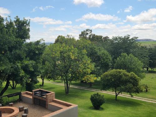 an aerial view of a park with trees and a fire pit at Merino Guest Farm in Clarens