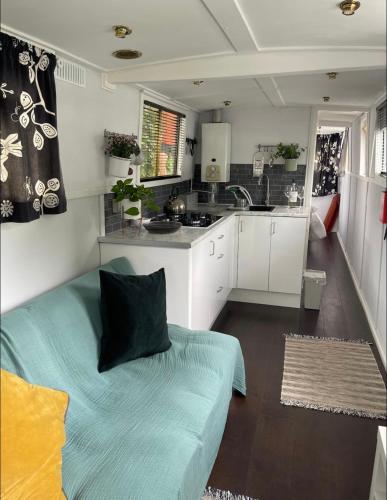 a living room with a couch and a kitchen at Narrow Boat moored in London in London