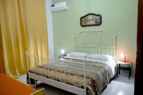 a bedroom with a bed with a green headboard at Home's Vita in Trapani