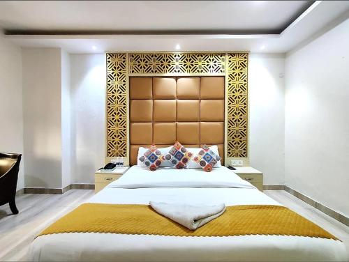 a bedroom with a large bed with a large headboard at Hotel Orchid Garden Karol Bagh in New Delhi