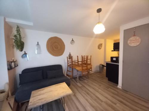 a living room with a blue couch and a table at Le cosy in Clermont-lʼHérault