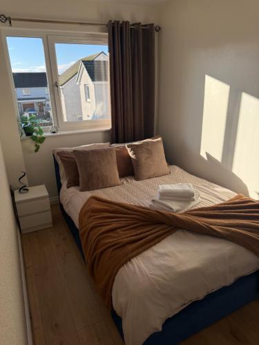a bedroom with a large bed with a window at Black Daisy in Glasgow