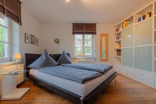 a bedroom with a large bed with blue sheets at Traum FeWo mit Garten und Bergblick nahe Chiemsee in Übersee