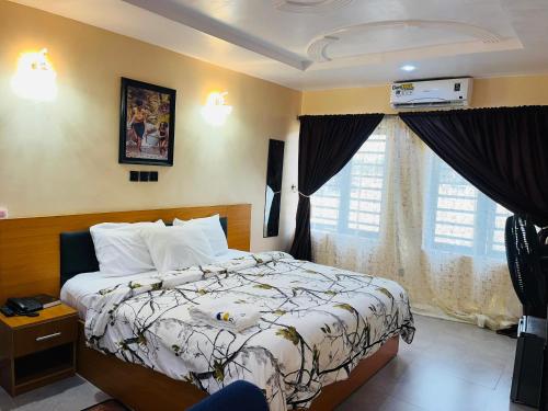 a bedroom with a bed and a large window at Dopad Hills Hotel and Suites in Ojo