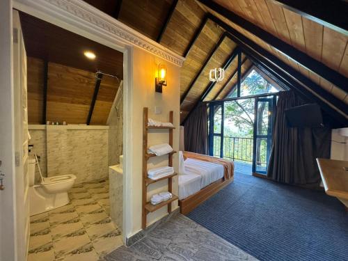 a bathroom with a bed and a sink and a toilet at Bluefield Cabana in Ramboda