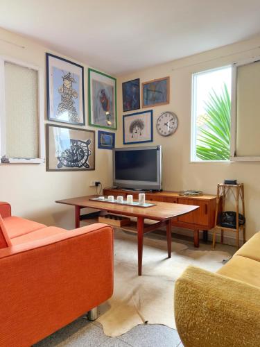 a living room with a table and a tv at Casa Vintage Seixal Madeira in Seixal
