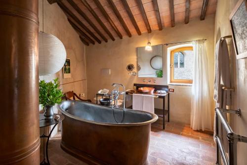 an old tub in a bathroom with a sink at Castello Di Vicarello in Sasso dʼOmbrone