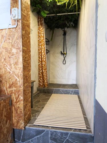 a shower stall with a wooden floor in a bathroom at Casa Vintage Seixal Madeira in Seixal