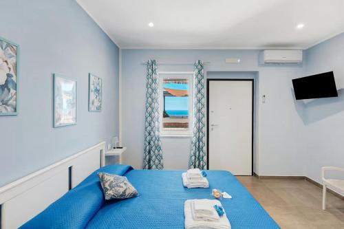 a blue bedroom with a blue bed and a window at La Fiesta House in Capaccio-Paestum