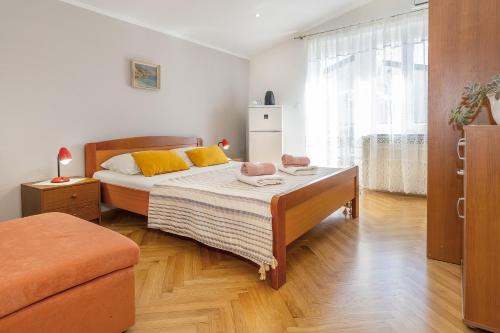 a bedroom with a bed with yellow pillows on it at Double Rooms Jasna with Sea View in Baška