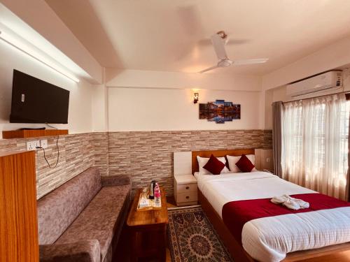 a hotel room with a bed and a couch at Hotel Kandara in Pokhara