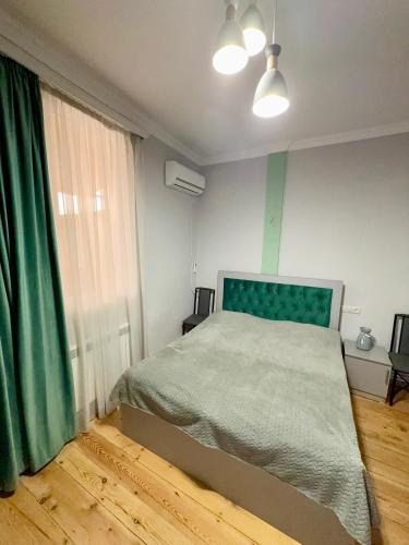 a bedroom with a bed and a green curtain at Ashtarak Garden GuestHouse in Ashtarak