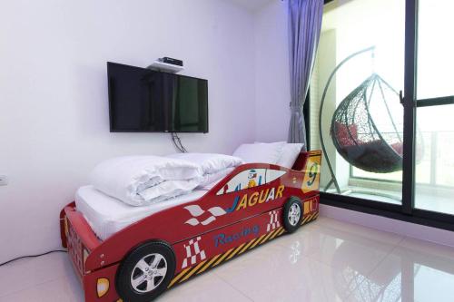 a toy car bed in a room with a tv at Candy House in Wujie