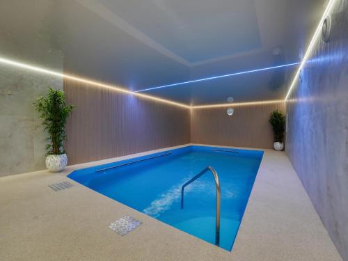 a swimming pool in a room with a blue ceiling at MAGNOLIA III in Świeradów-Zdrój