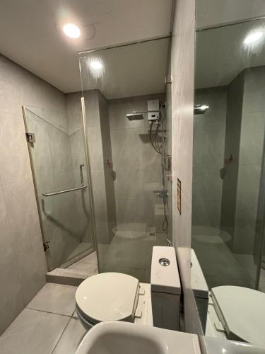 a bathroom with a shower and a toilet and a sink at Sunnyplace Residences Near NAIA Airport in Manila