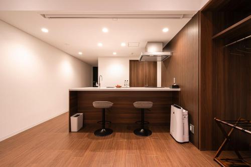 a kitchen with a counter and stools in a room at Cava House - Vacation STAY 07286v in Tokyo