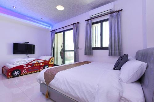 a bedroom with a bed and a toy car in it at Candy House in Wujie