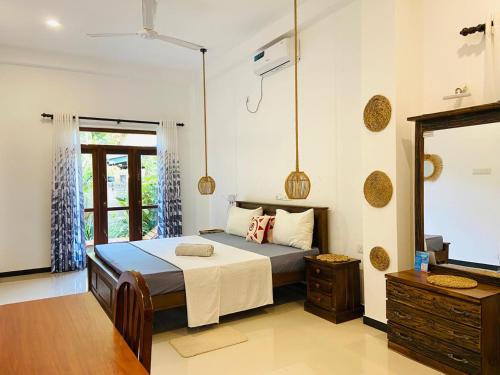 a bedroom with a large bed and a mirror at Diamond Key Ahangama in Piyadigama