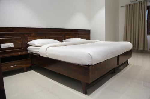 a bedroom with a large bed with white sheets at Wariyam Heritage in Trichūr