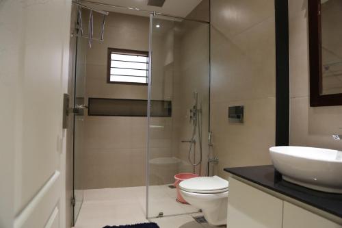 a bathroom with a shower and a toilet and a sink at Wariyam Heritage in Trichūr