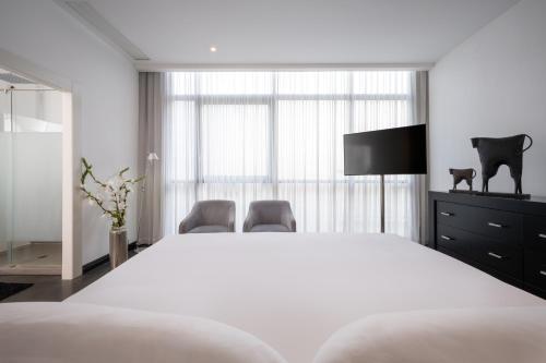 a bedroom with a large white bed and two chairs at Leonardo Boutique Hotel Tel Aviv in Tel Aviv