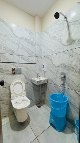 a bathroom with a white toilet and a sink at Hotel Shri Kaila Devi in Ujjain