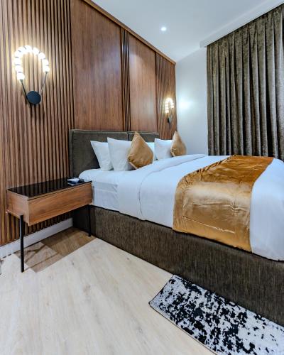 a bedroom with a large bed and a wooden wall at Atlantis Hotel Lagos in Lagos