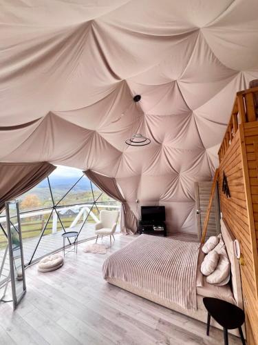 a bedroom with a bed in a tent at Forest glamp in Yasinya