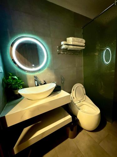 a bathroom with a sink and a toilet and a mirror at Serena Tam Coc Hotel & Villa in Ninh Binh